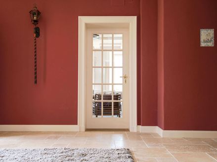 Eingangsbereich mit Travertinfliesen und roten Wänden