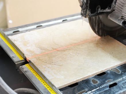 Eine Säge schneidet hellen Naturstein