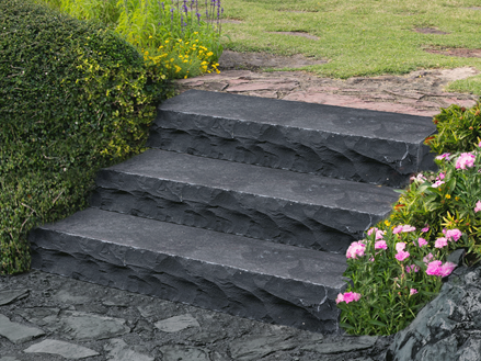 Blockstufen Basalt Takeda bossiert mit Blumen und Gebüsch