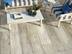Terrasse mit weißen Gartenmöbeln und Holzoptikplatten von oben fotografiert