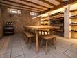 Weinkeller mit rustikalen Holzmöbeln, Weinregalen und grauen Sandsteinplatten als Bodenbelag