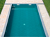Pool umrandet von hellen Travertinplatten aus der Luft fotografiert