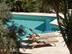 Zwei Liegen in der Sonne an einem Pool, Travertin Platten in hellem Beige als Bodenbelag