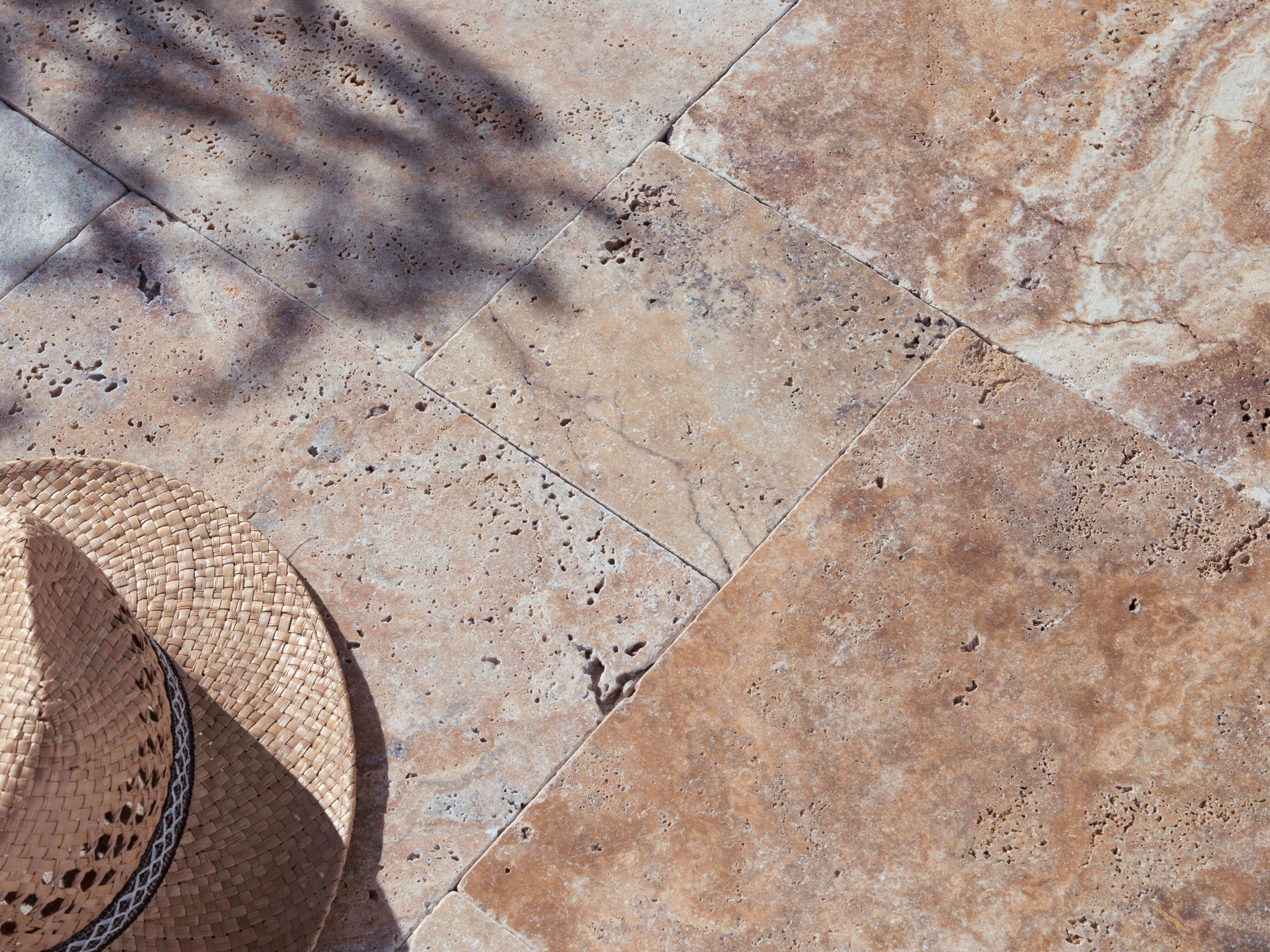 Travertin Scabas-Terrasse im Sonnenlicht mit Strohhut