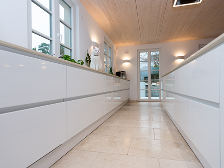 Offene Küche mit Cleopatra Light Kalksteinfliesen und weißen Küchenmöbeln