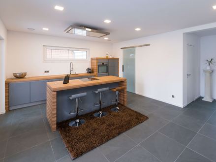 Küche mit Holzelementen und Schieferfliesen in zartem Grau als Bodenbelag