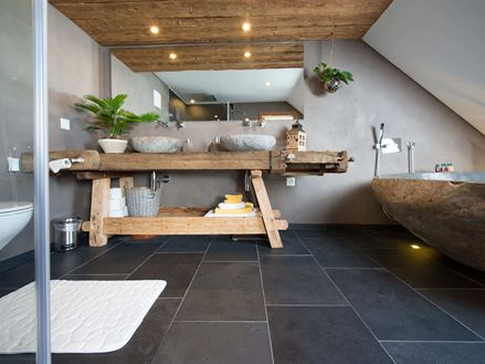 Rustikales Bad mit Schieferfliesen und Holzmöbeln
