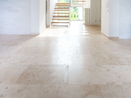 Große Fläche mit Travertinfliesen in hellem Beige, im Hintergrund eine Treppe