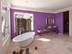 Badezimmer mit Travertin Light Fliesen, lila Wand und freistehender Wanne