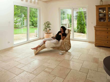 Frau liegt in Liegestuhl auf Travertinfliesen Light