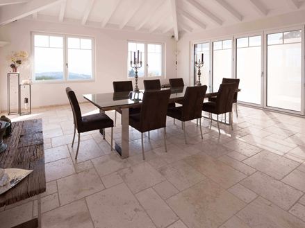 Esszimmer mit hoher Decke, Tisch und Stühlen auf Travertin Light in römischem Verband