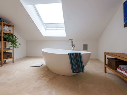 Bad mit Travertin Medium Line, freistehende Badewanne und Handtuch