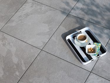 Carreaux de grès cérame fin en forme d'ardoise grise avec un plateau de café