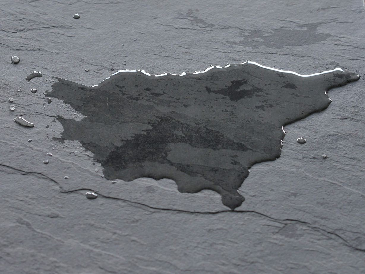 Dunkle Schieferfliese mit Wasserlache