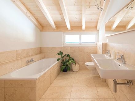 Travertin-Fliesen Classic Light in einem Badezimmer mit Wanne