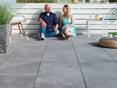 Personen genießen die Sonne auf einer Terrasse mit Platten Alpine Grey