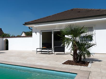 Mediterrane Travertin-Terrasse mit Poll und Palme