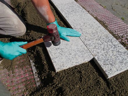 Platten werden im Einkornmörtel auf einer Schottertragschicht verlegt