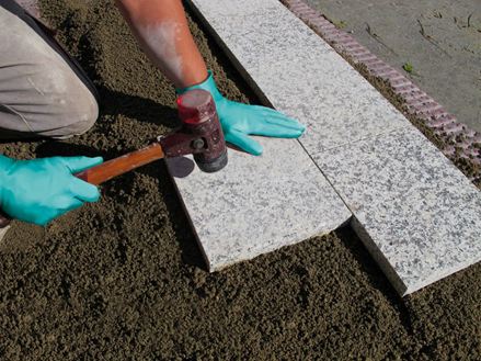 Platten werden im Einkornmörtel auf einer Schottertragschicht verlegt