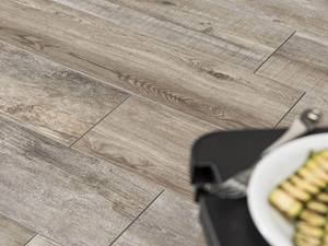 Authentische Maserungen für puren Holzlook Verlegte Platten in Holzoptik mit Tisch und Essen in der Ecke