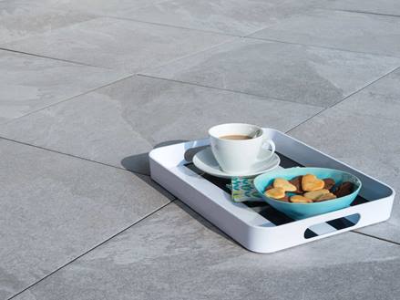 Tablett mit Kaffee und Keksen auf verlegten Schieferoptikplatten Alpine Grey in hellem Grau