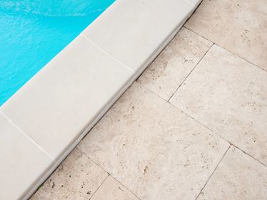 Poolrand mit hellem Travertin