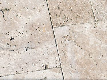 Nahaufnahme von Travertinplatten in hellem Beige mit travertintypischen Poren